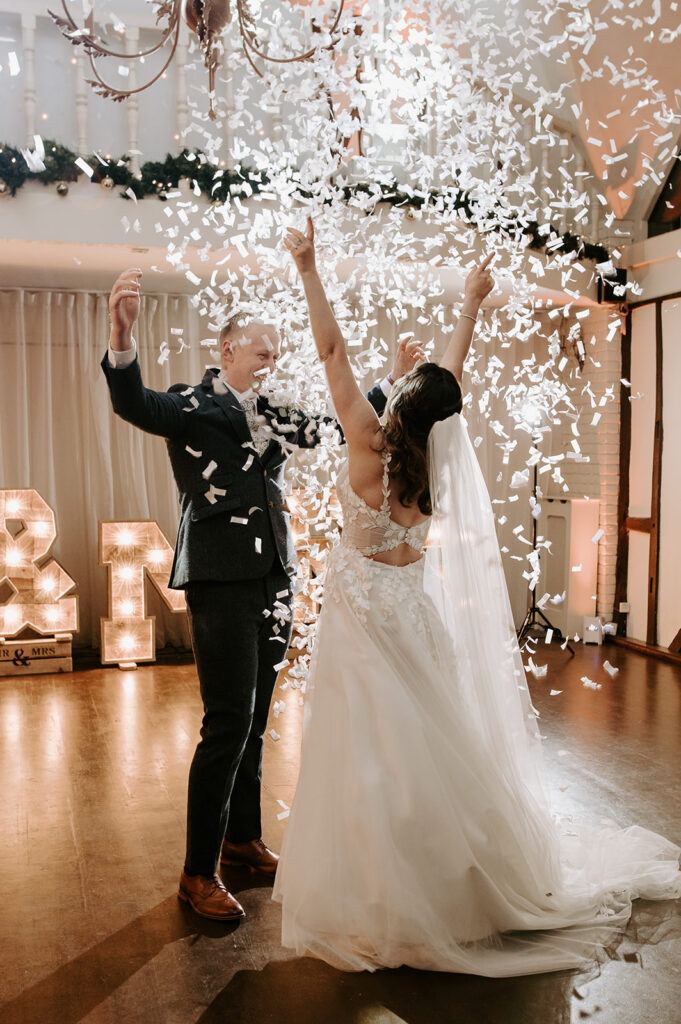 bride and groom celebrating with confetti canons going off during first dance