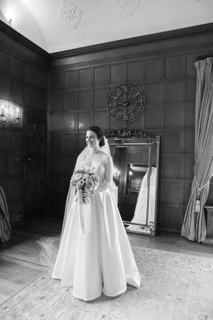 bride smiling holding bouquet at hengrave hall