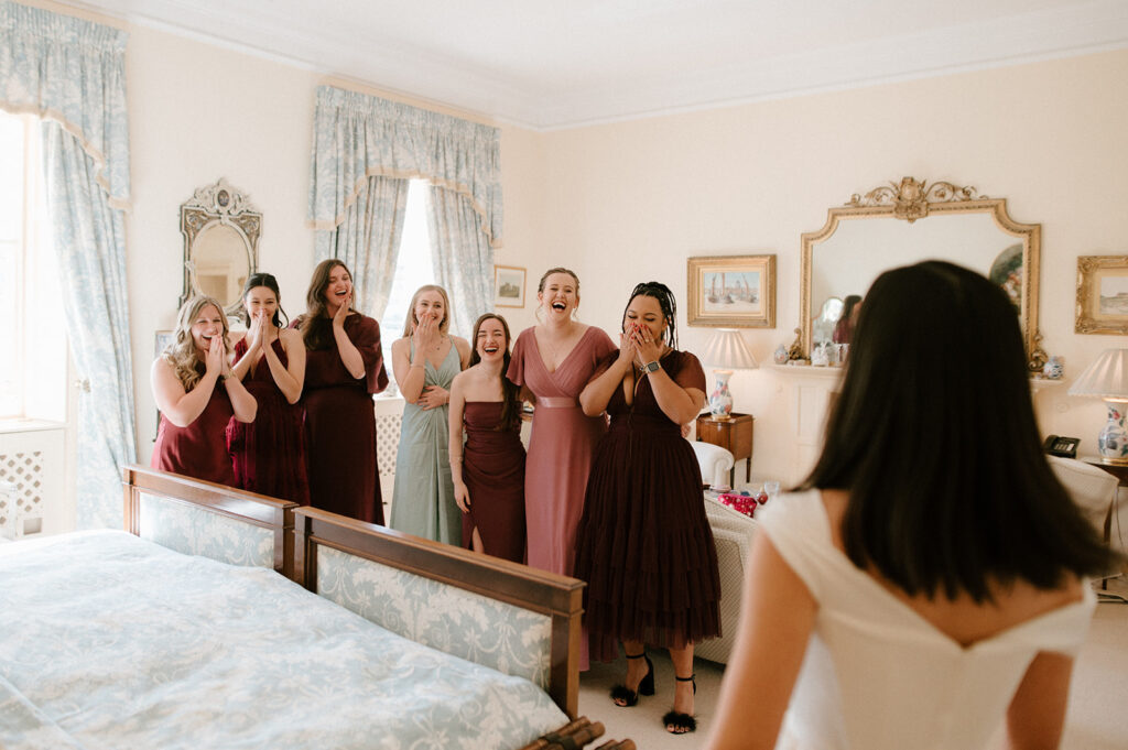 photo of bridesmaids reacting to seeing the bride