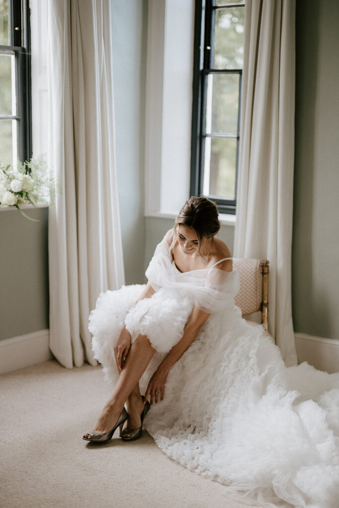 bride putting wedding shoes on at sandon manor