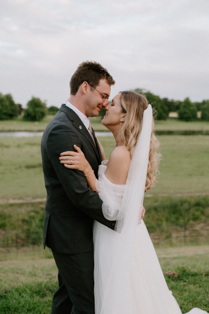 bride and groom looking at each other at wilderness reserve with long wedding veil