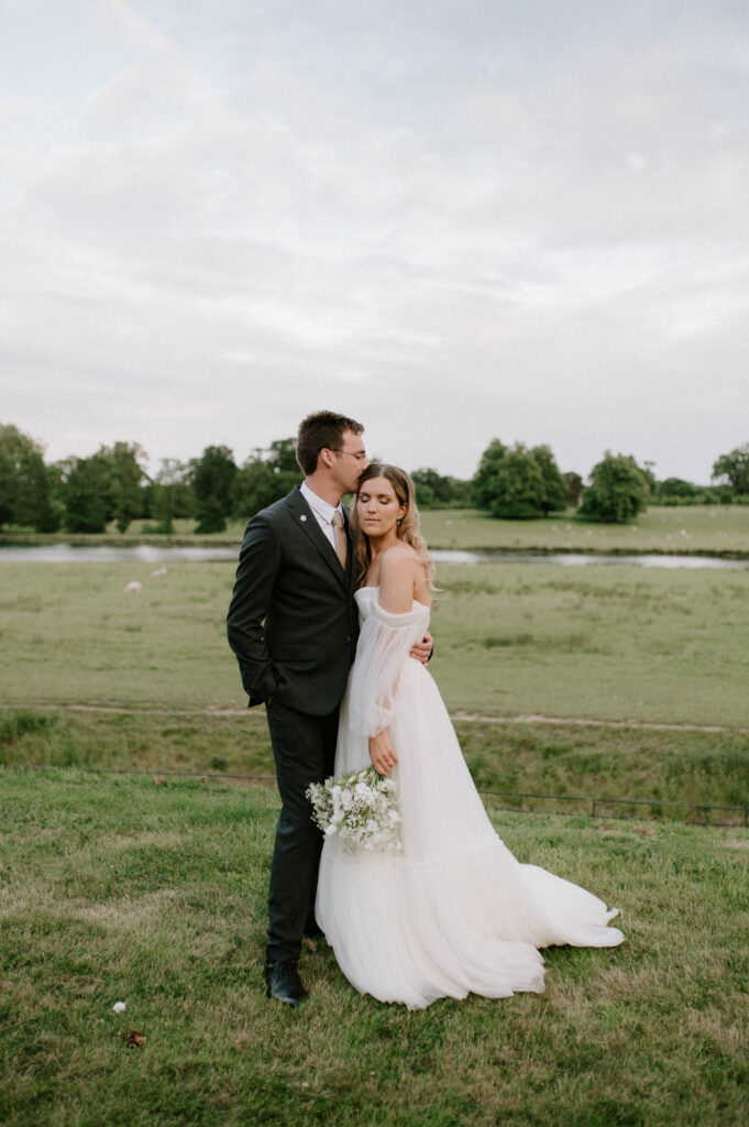 groom kissing bride on forehead at wilderness reserve