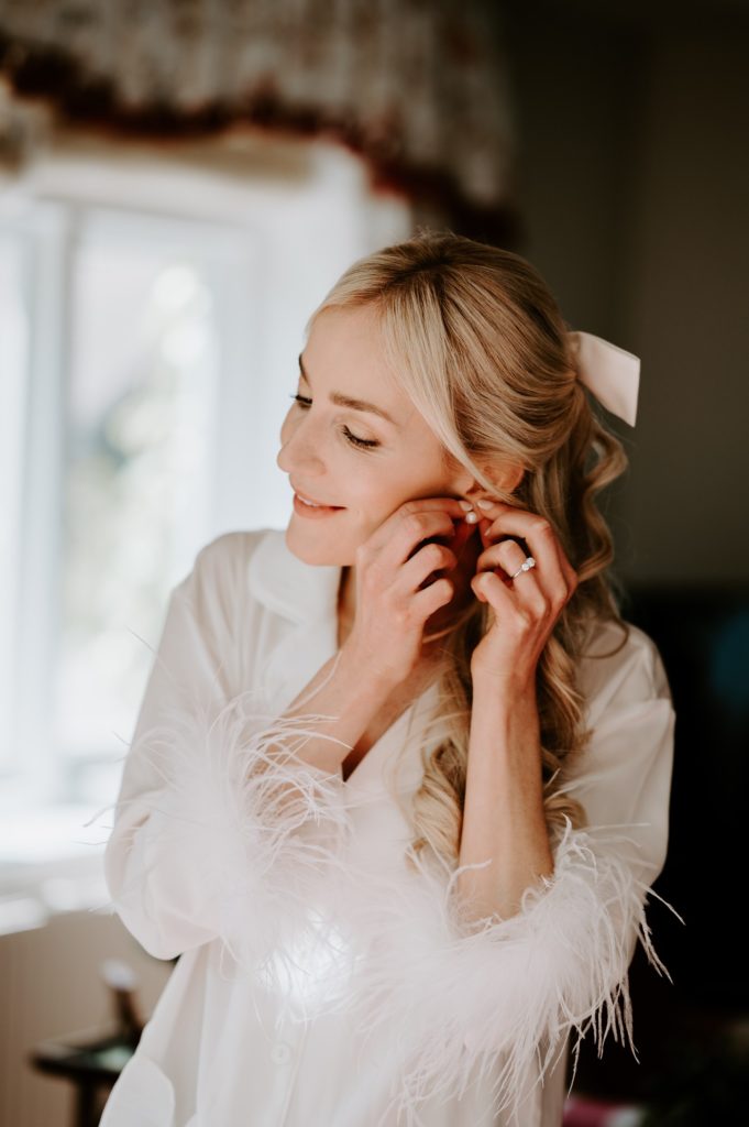 bride putting earrings on