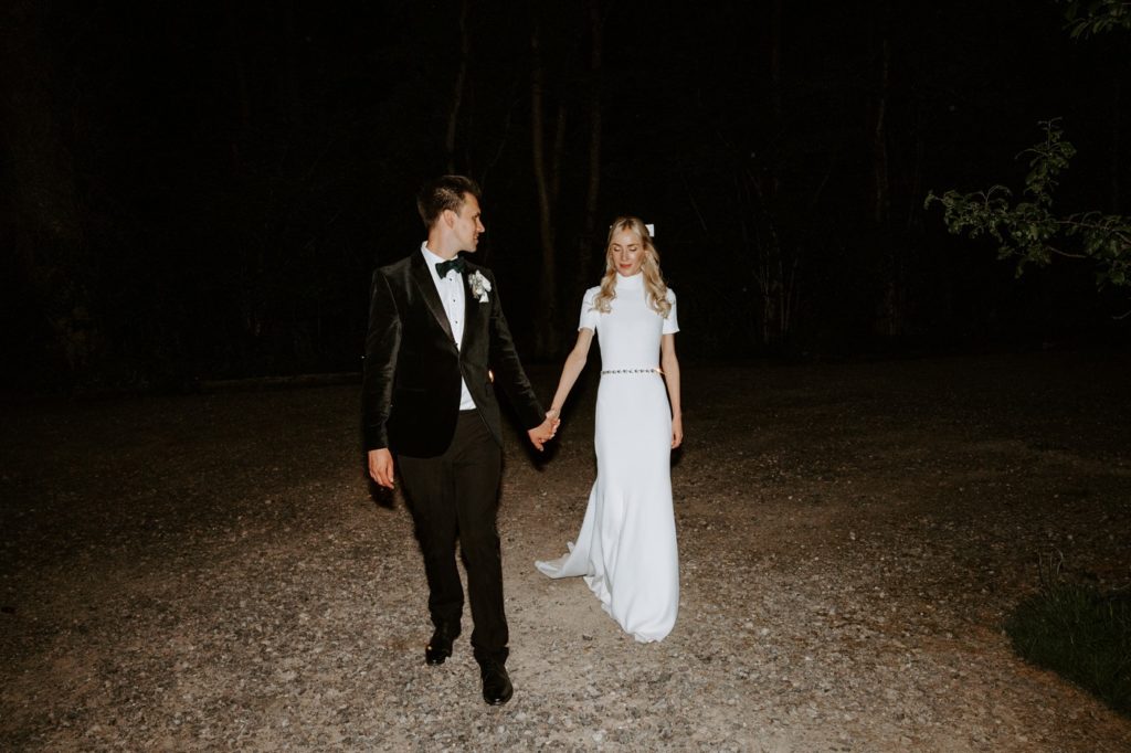 couple at night with vintage wedding car 