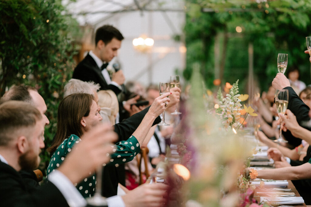 guests raising a glass during wedding speeches