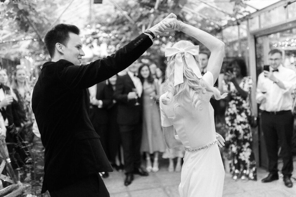 groom twirling the bride during first dance at West Green house gardens