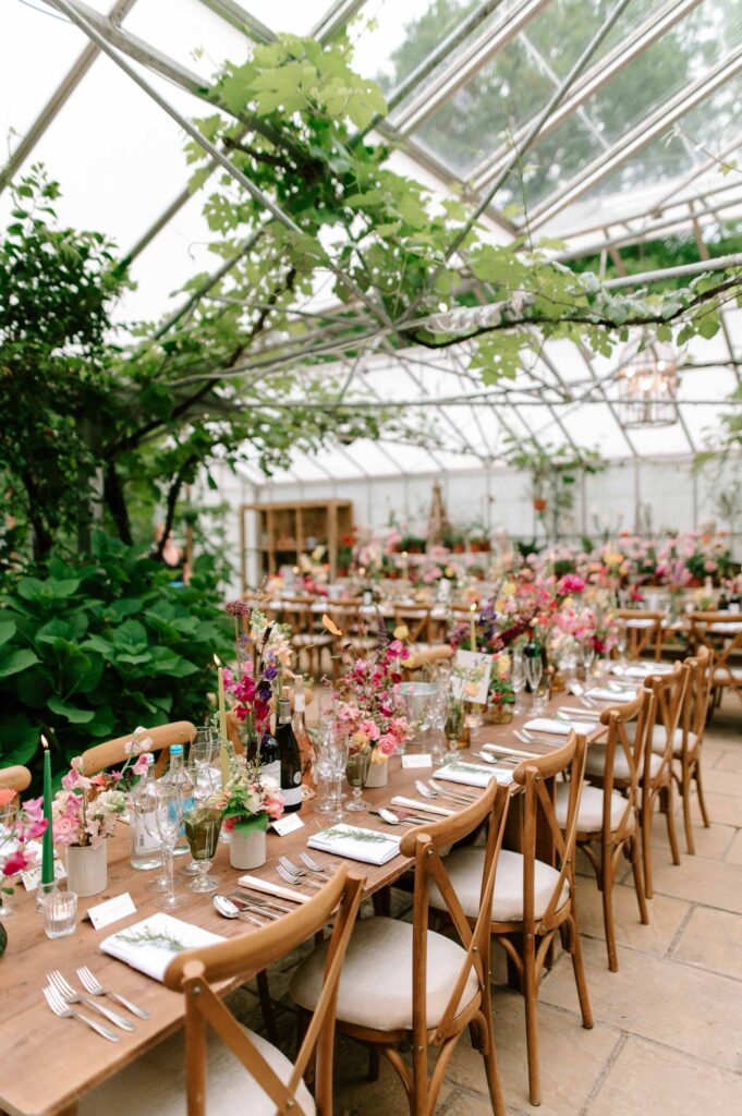intimate wedding setup in greenhouse with lots of foliage and florals