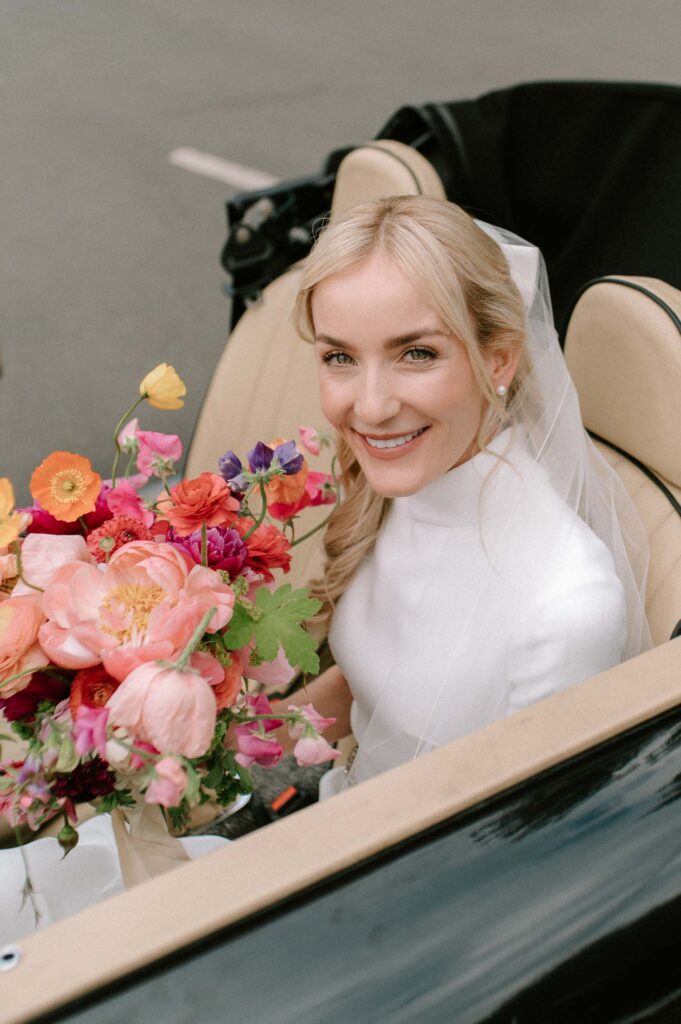bride in car holding bouquet on way to West Greenhouse gardens Hampshire wedding venue