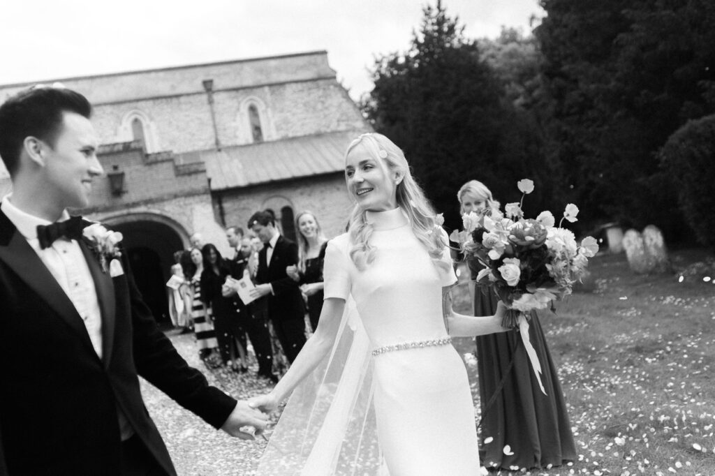 candid moment of bride and groom holding hands