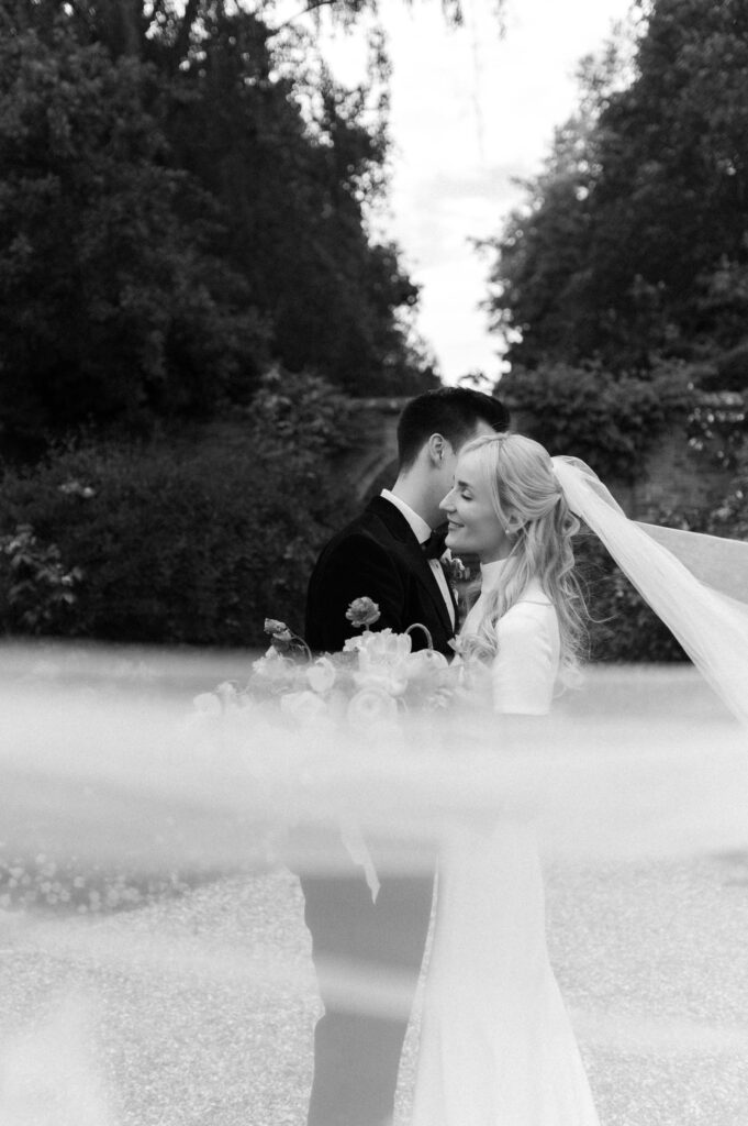 bride and groom with veil sweeping across 