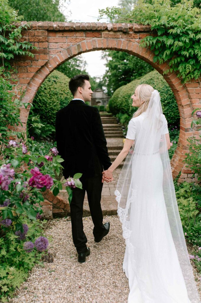 bride and groom walking in West Green house gardens