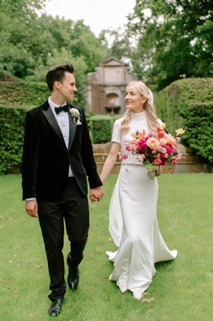 bride and groom walking towards the camera smiling and chatting