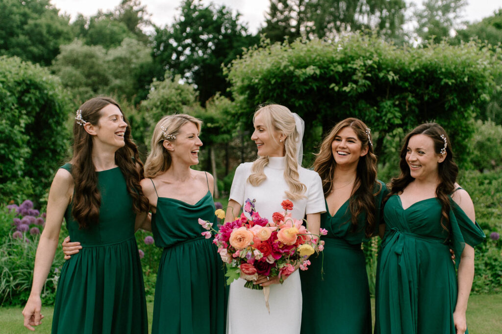 bride and bridesmaids smiling at each other