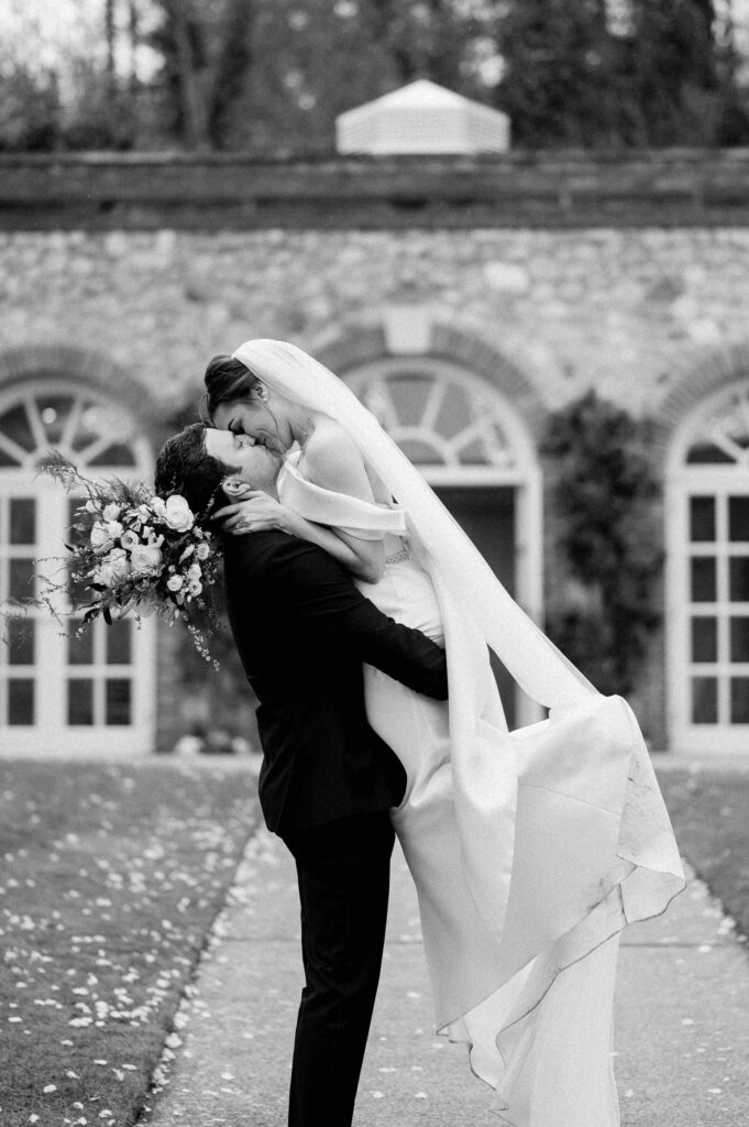 groom picking up bride in front of orangery maidstone wedding venue Kent