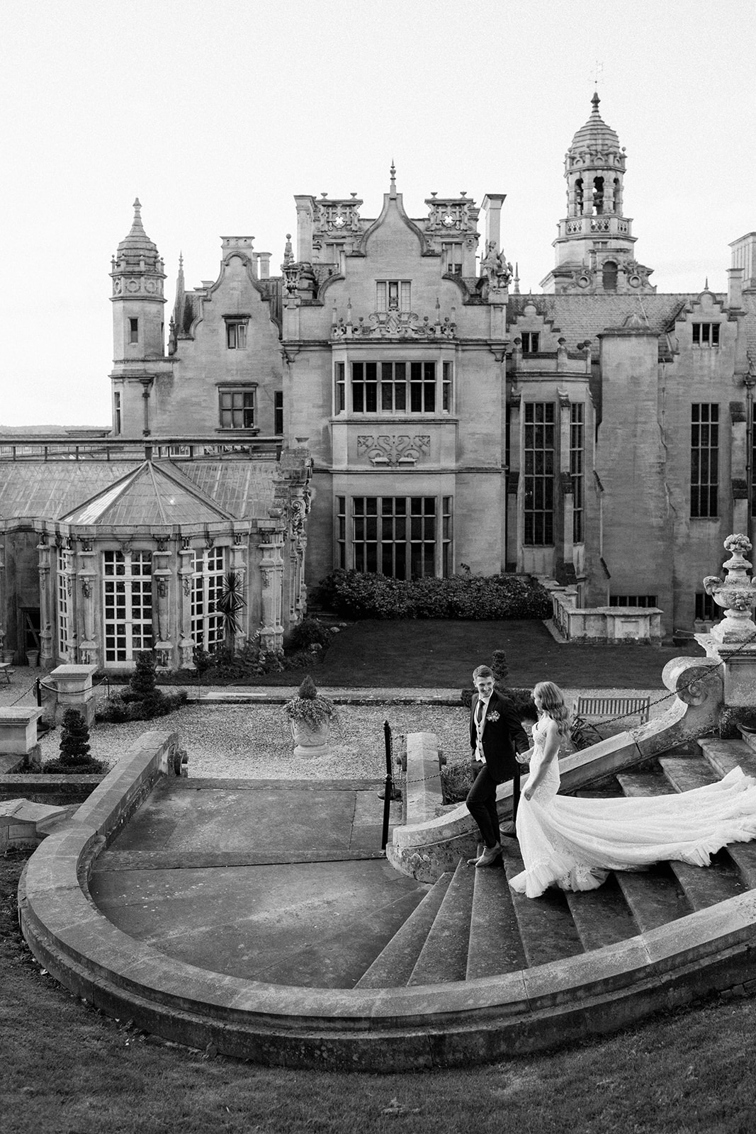 bride and groom walking down stairs at Harlaxton Manor
