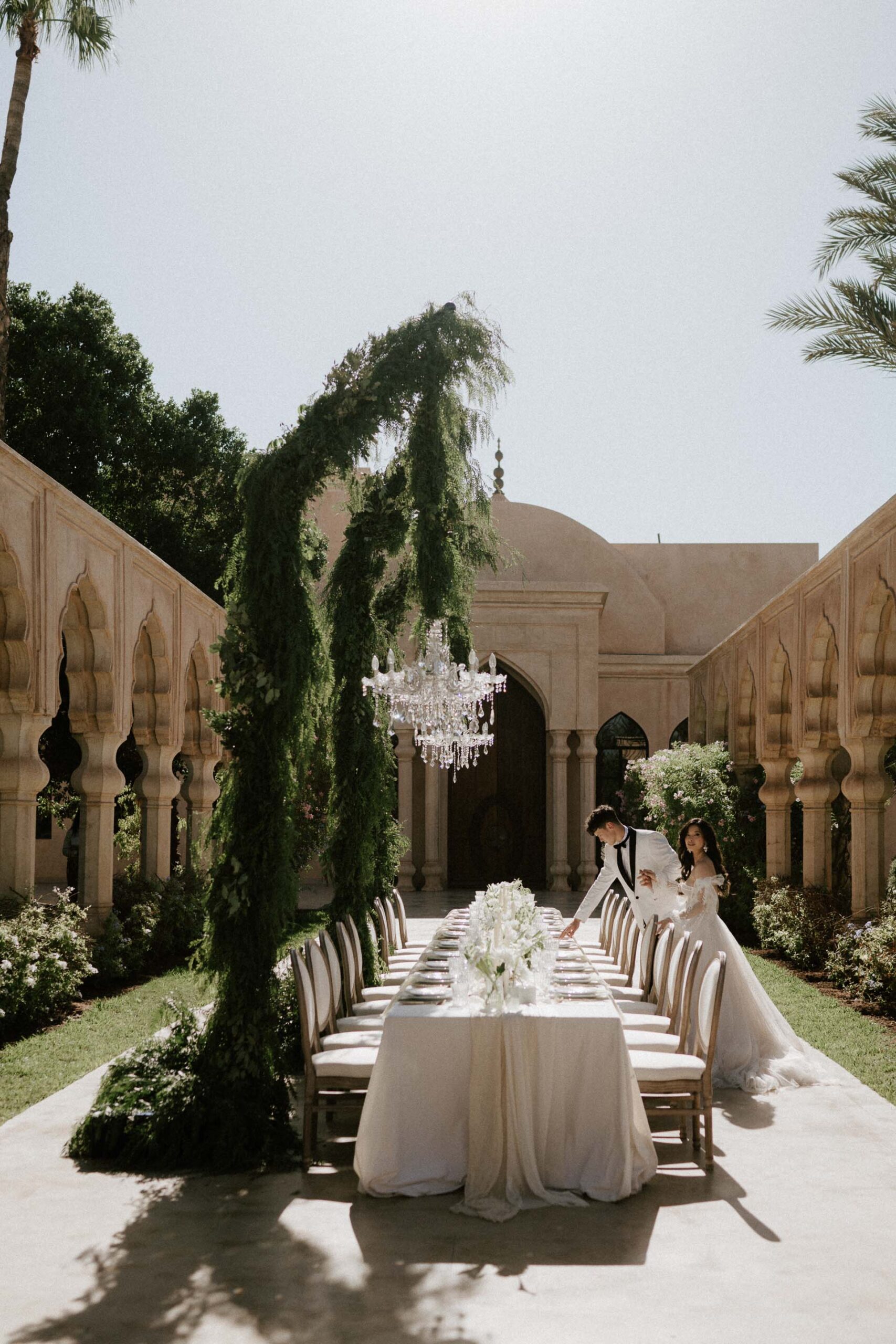 bride and groom walking by reception table set up in palais namaskar