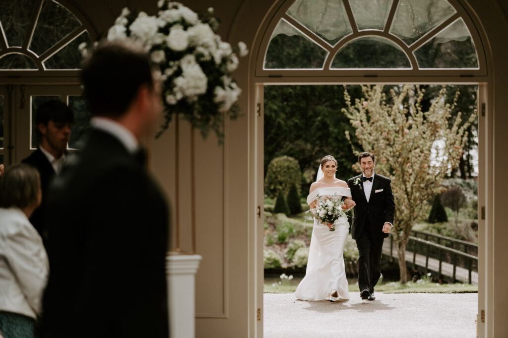 bride walking down the aisle for wedding ceremony at the orangery in maidstone