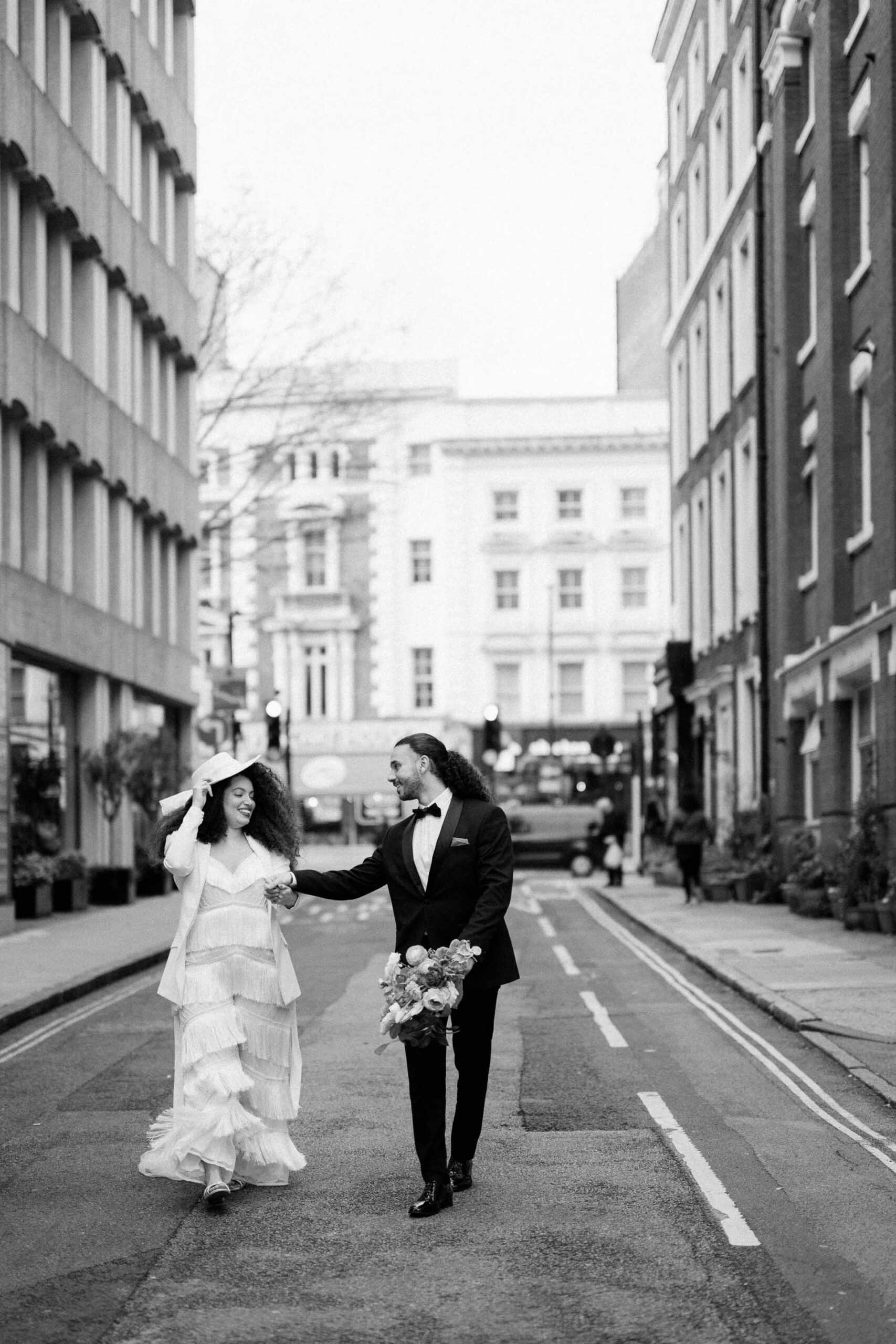 bride and groom walking down street in london