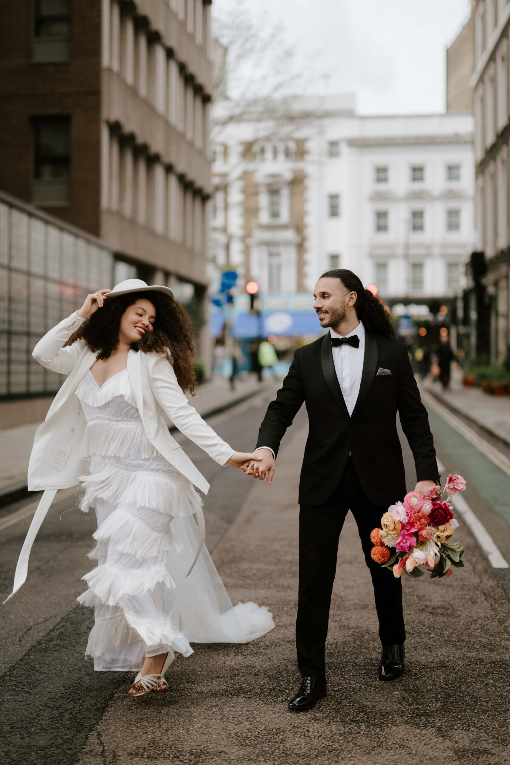 bride and groom walking down street in london