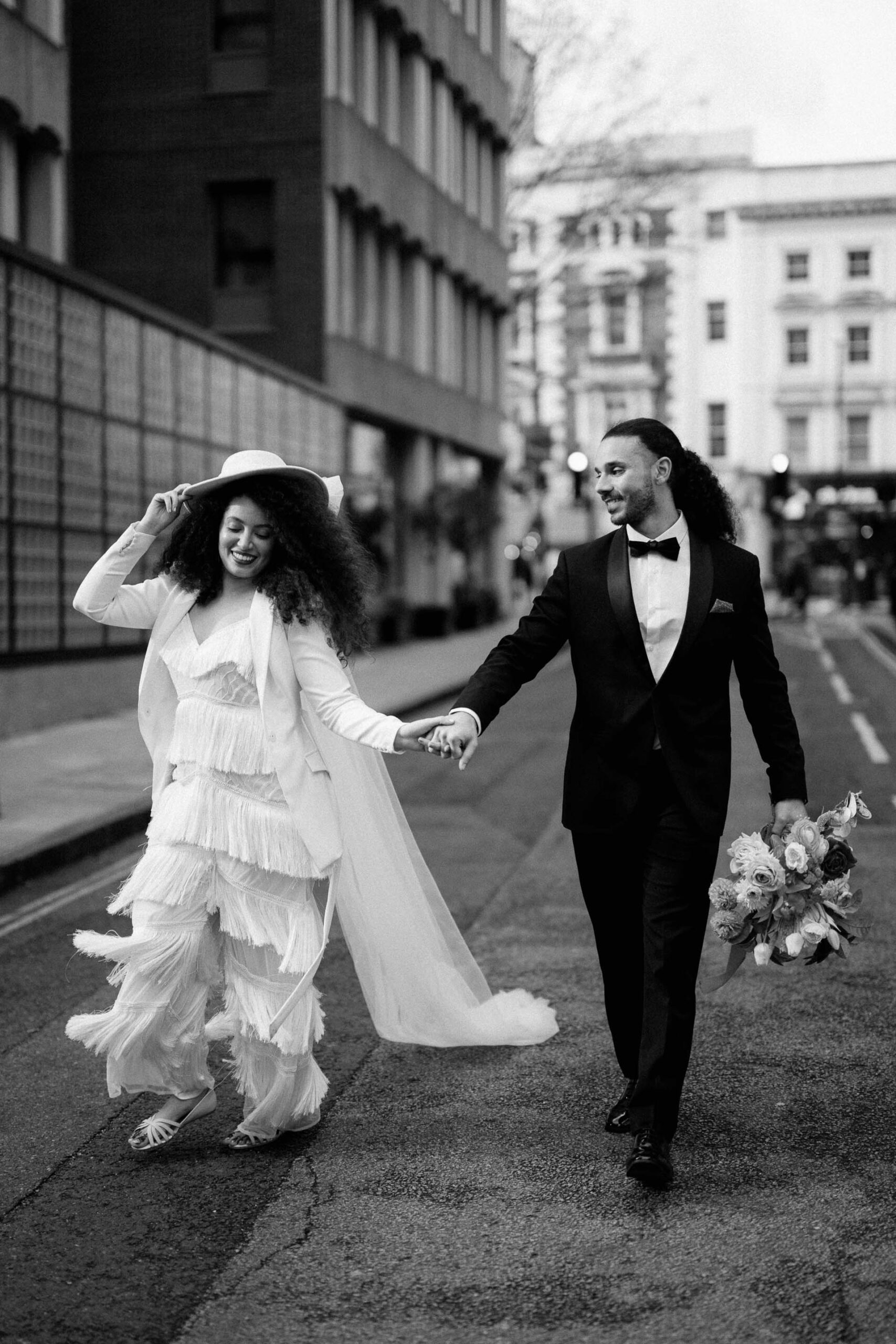 bride and groom walking down street in london