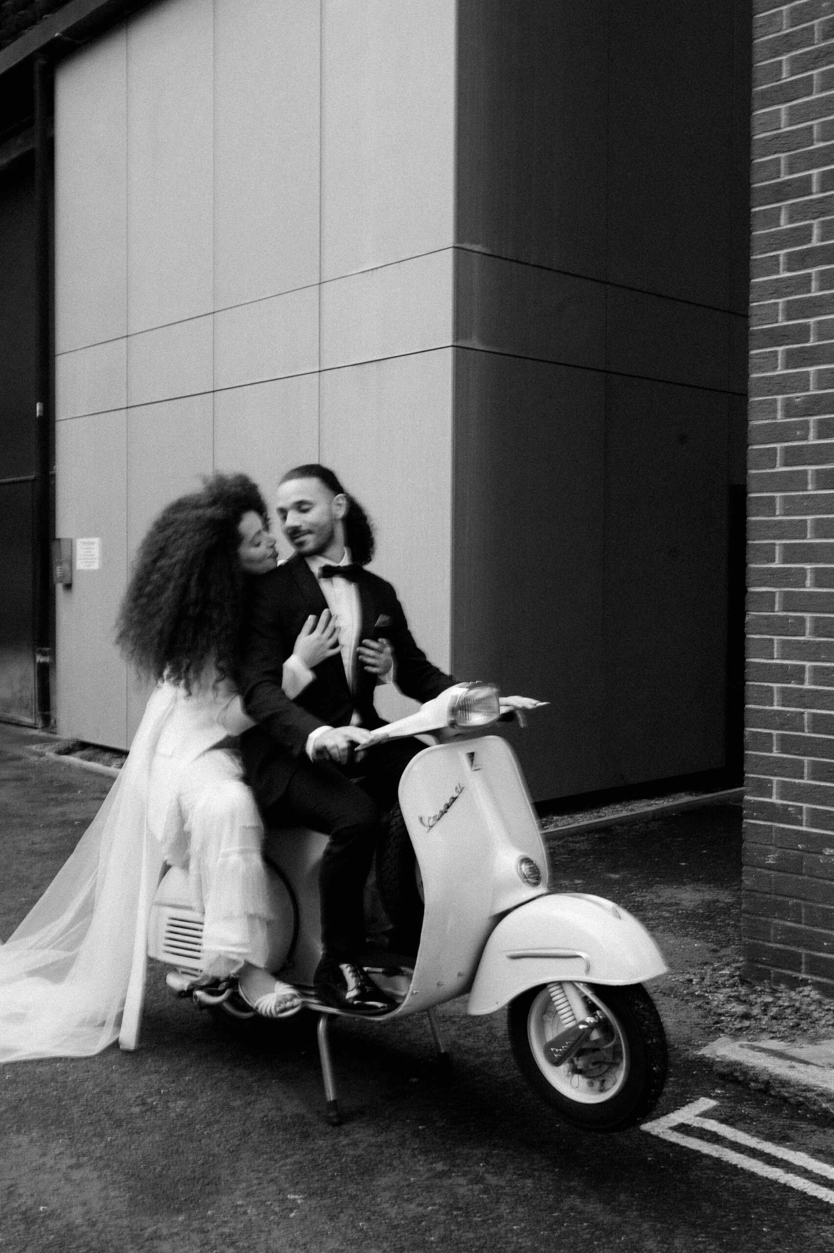 bride and groom riding vespa down streets of london