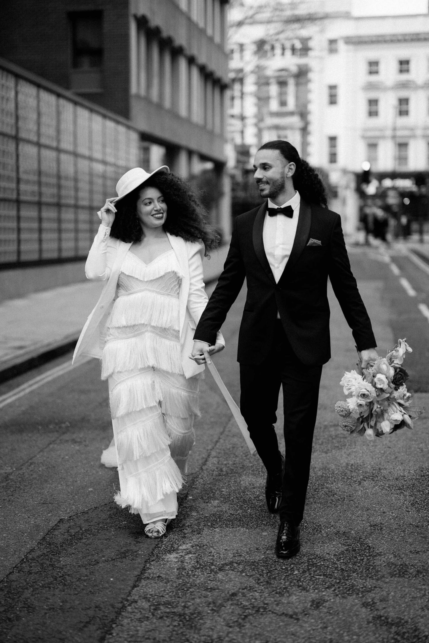 bride and groom walking down street in london