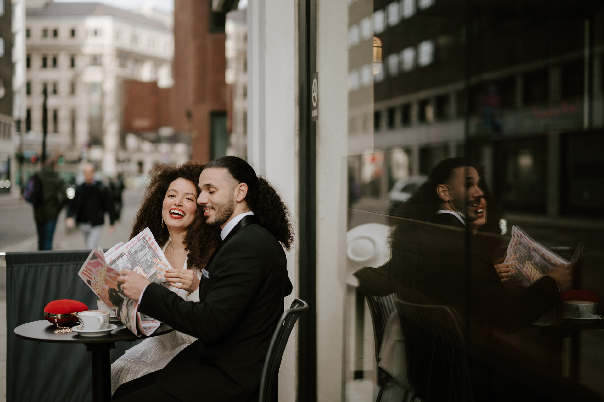 bride and groom at coffee shop drinking coffee reading newspaper