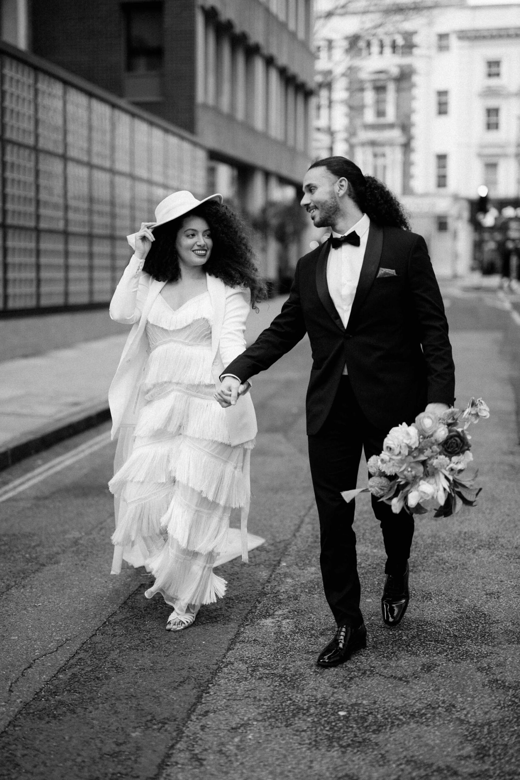 bride and groom walking down street in london