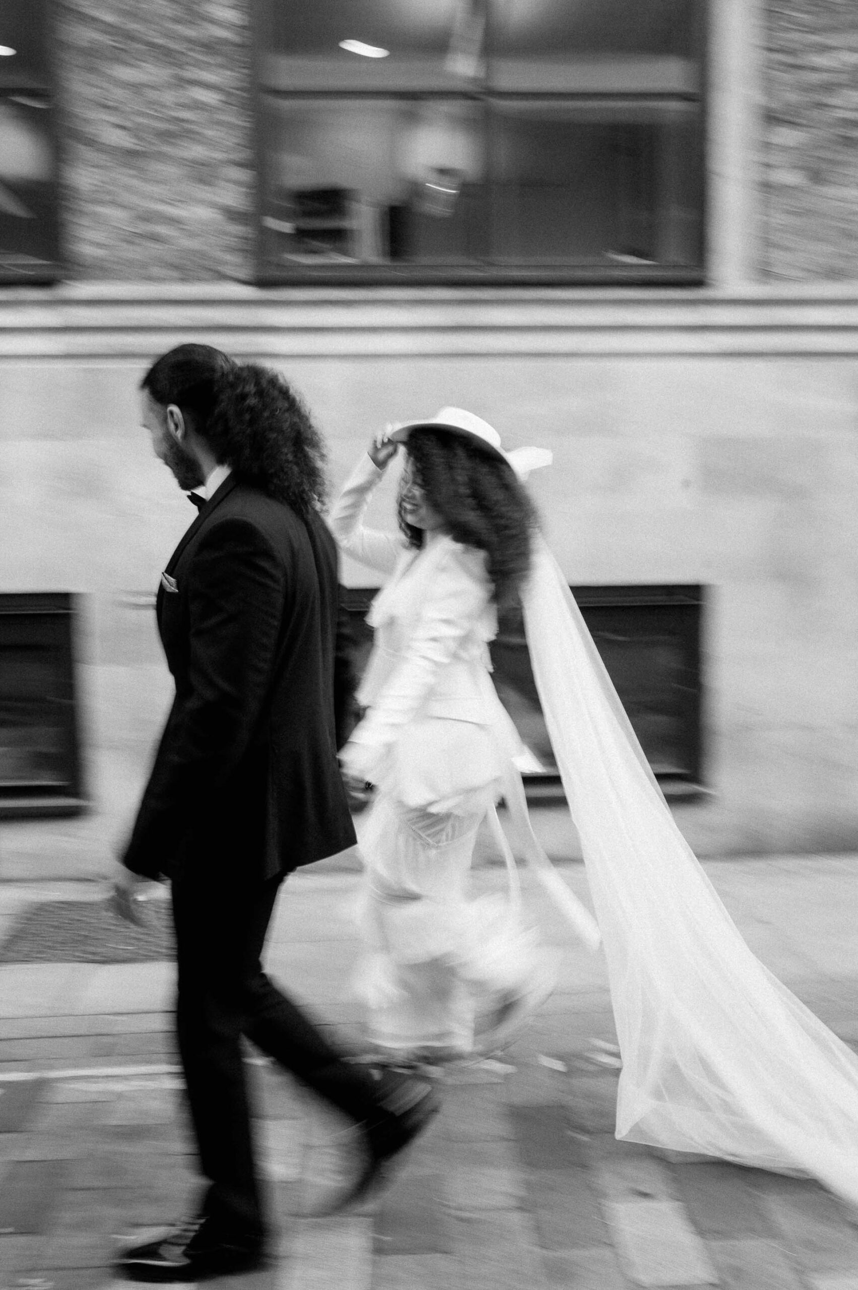 bride and groom walking down street in London with motion blur