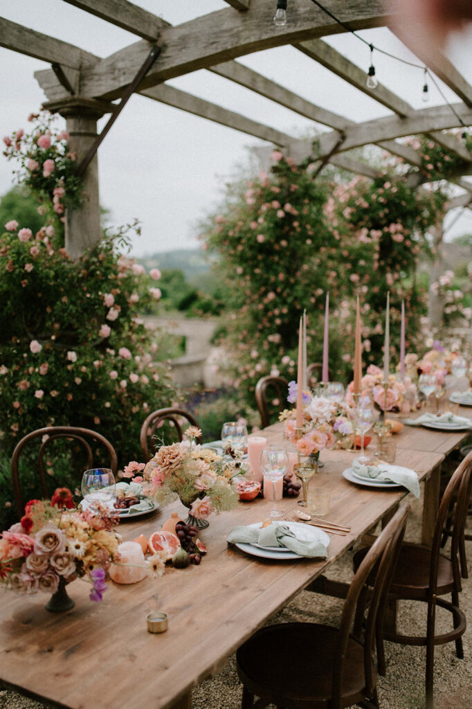 colourful outdoor wedding breakfast set up with spring florals and candlesticks at Euridge manor