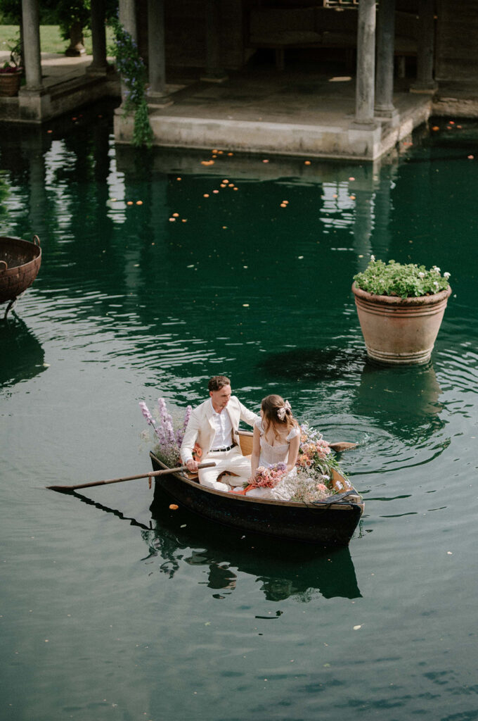 bride and groom in boat on lake at euridge manor