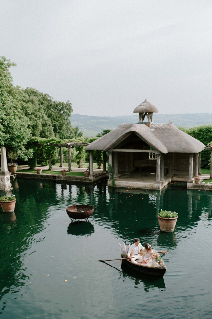 bride and groom in boat on lake at euridge manor