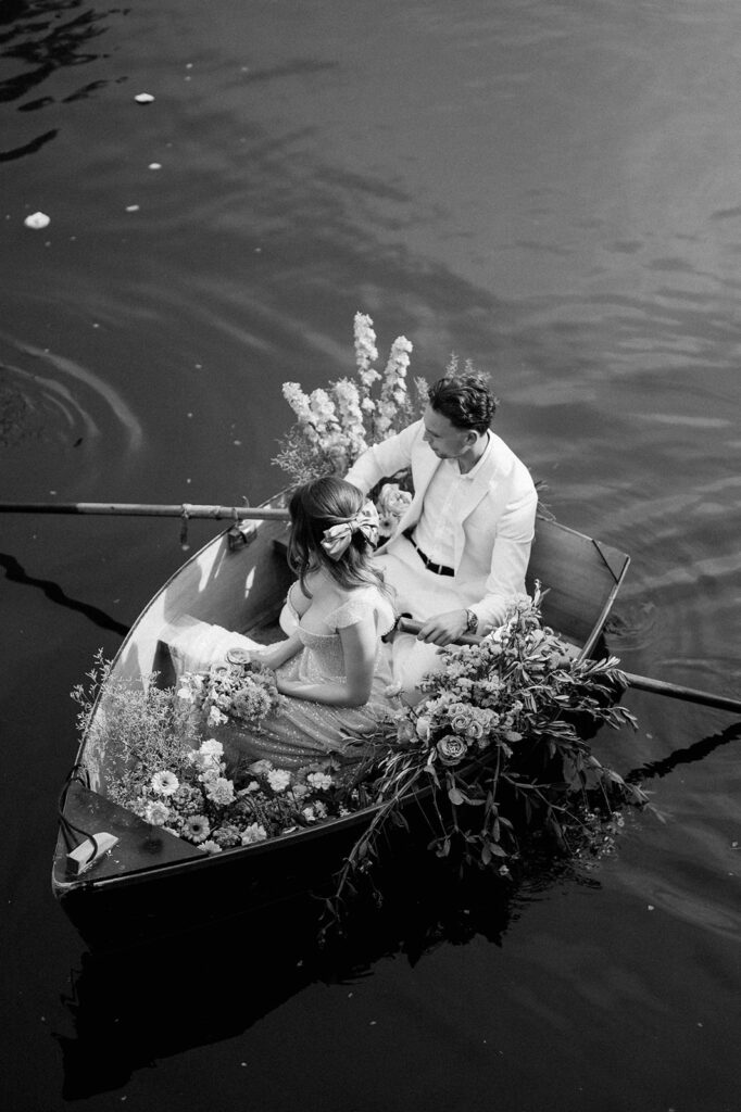 bride and groom in boat on lake at euridge manor
