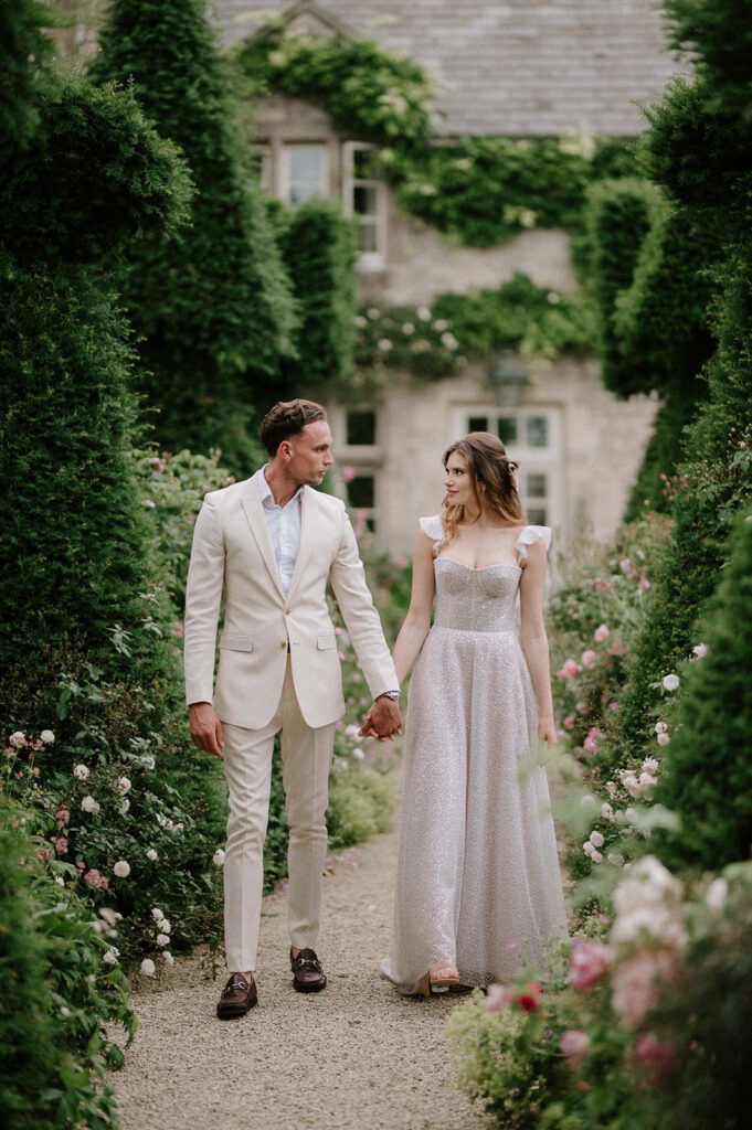 bride and groom walking through gardens at euridge manor