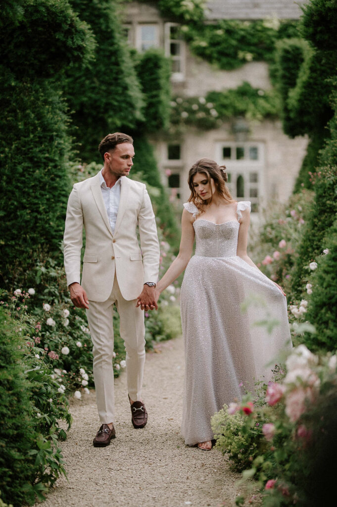 bride and groom walking through gardens at euridge manor