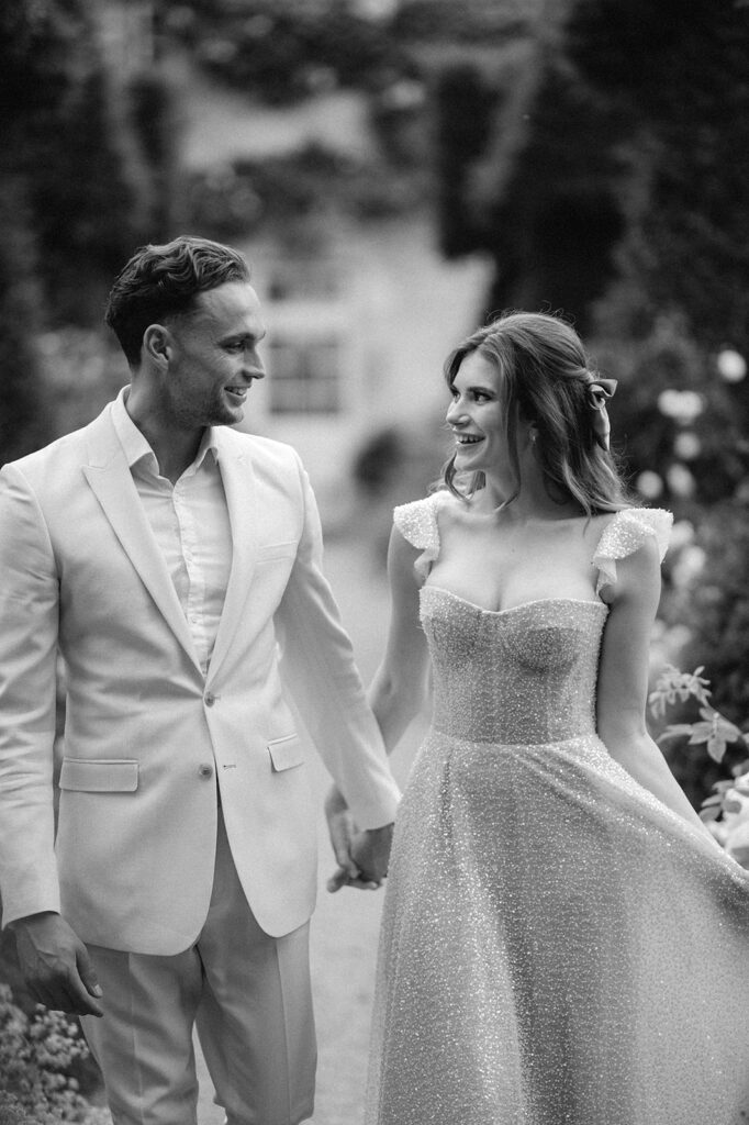 bride and groom walking through gardens at euridge manor