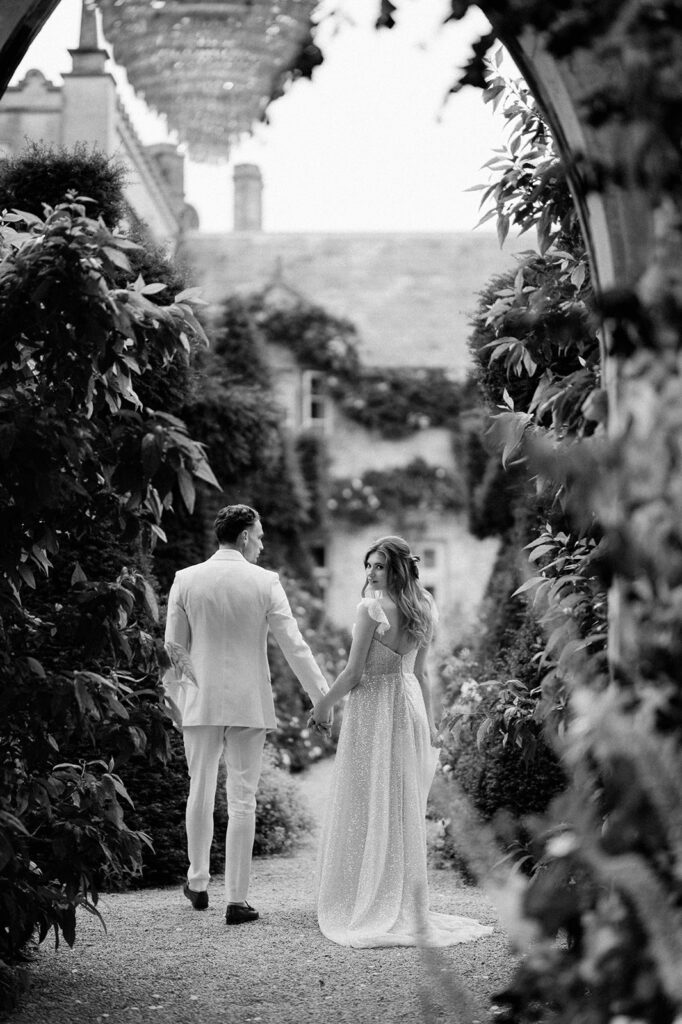 bride and groom walking through gardens at euridge manor