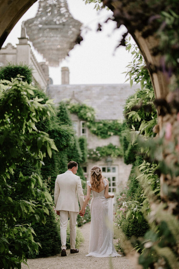 bride and groom walking through gardens at euridge manor