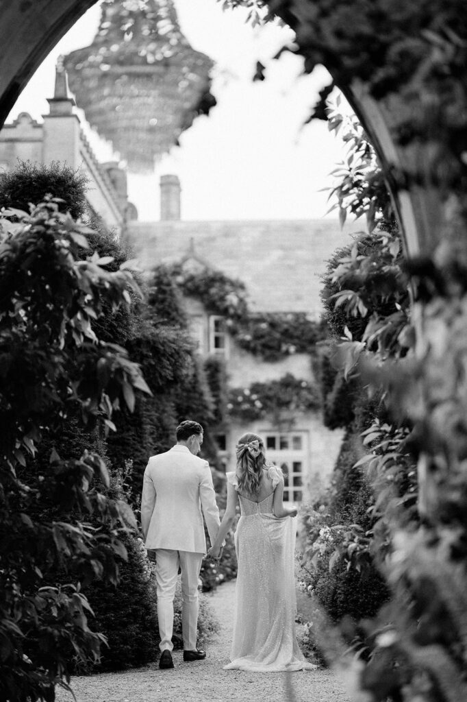 bride and groom walking through gardens at euridge manor