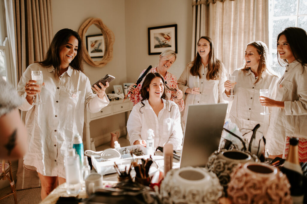 bride getting ready surrounded by bridesmaids
