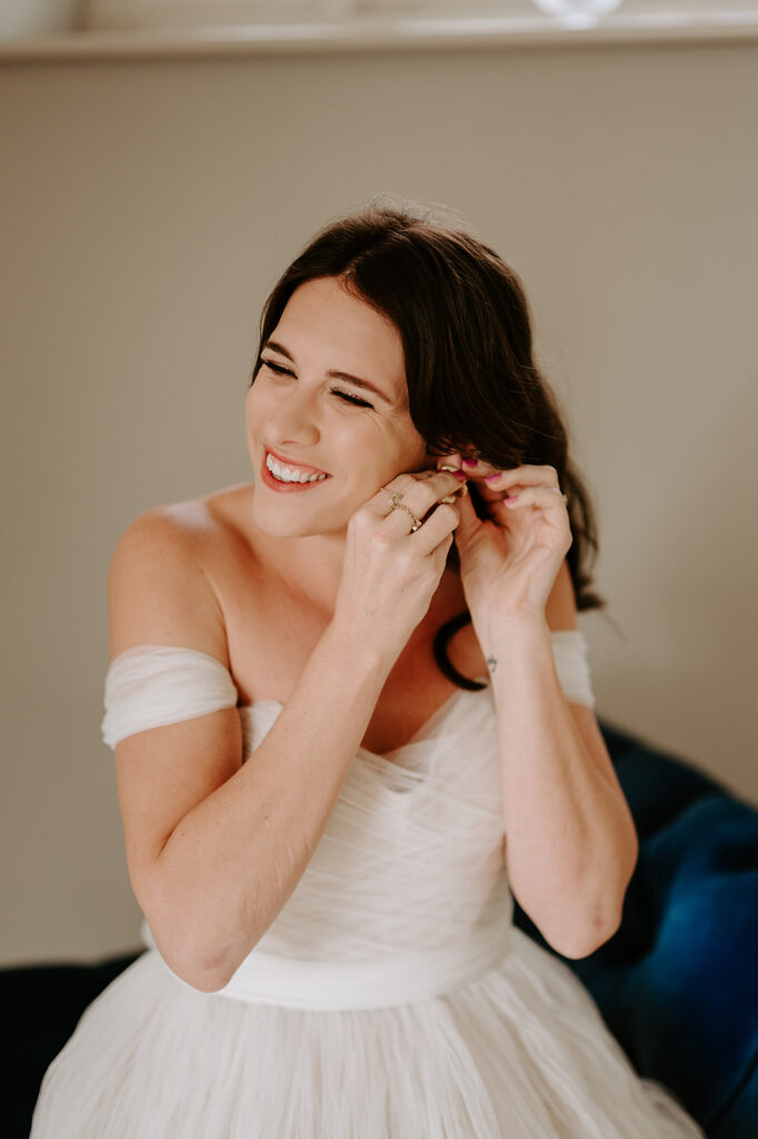bride putting on earrings