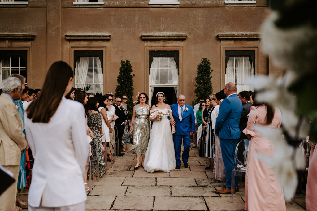 bride walking down aisle with parents