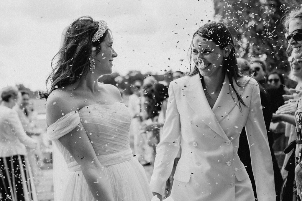 two brides walking back down aisle with confetti