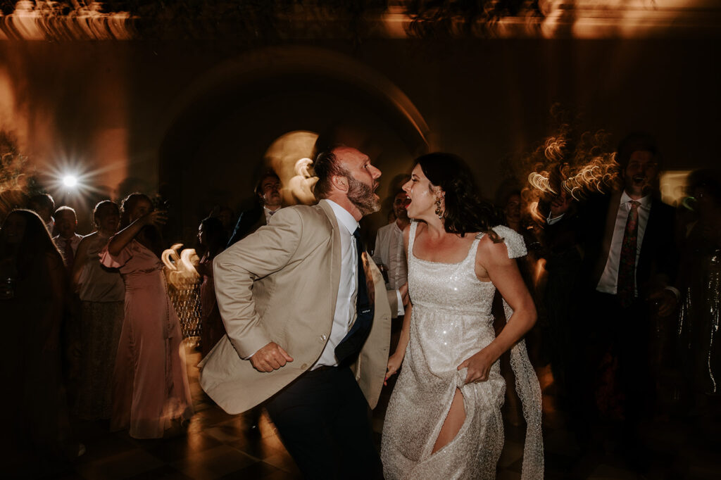 bride in sparkly dress dancing with wedding guest
