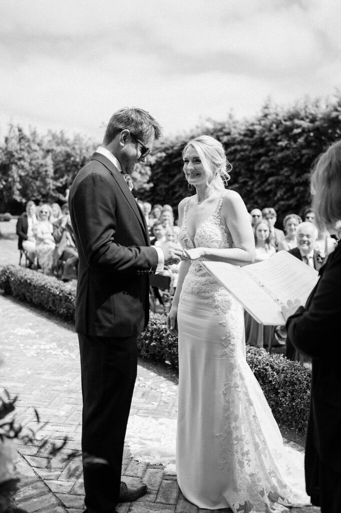 couple exchanging rings during outdoor ceremony at retreat east