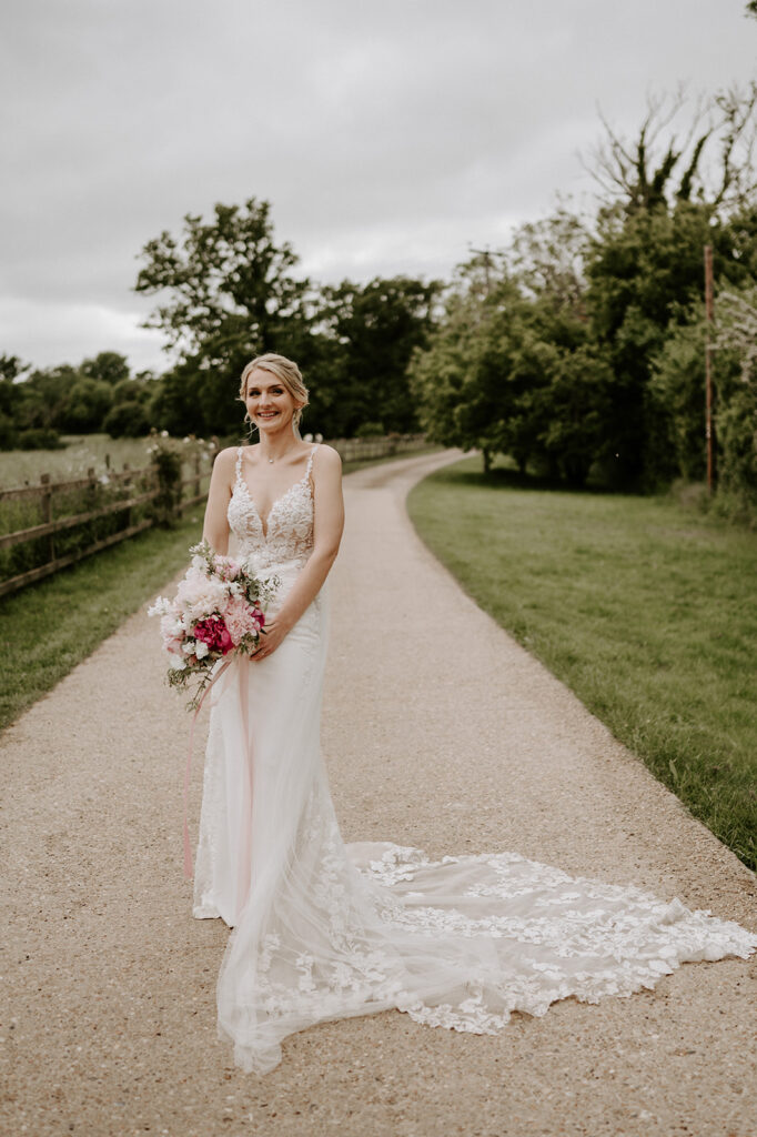bride wearing Martina liana wedding dress at retreat east holding pink peony wedding bouquet