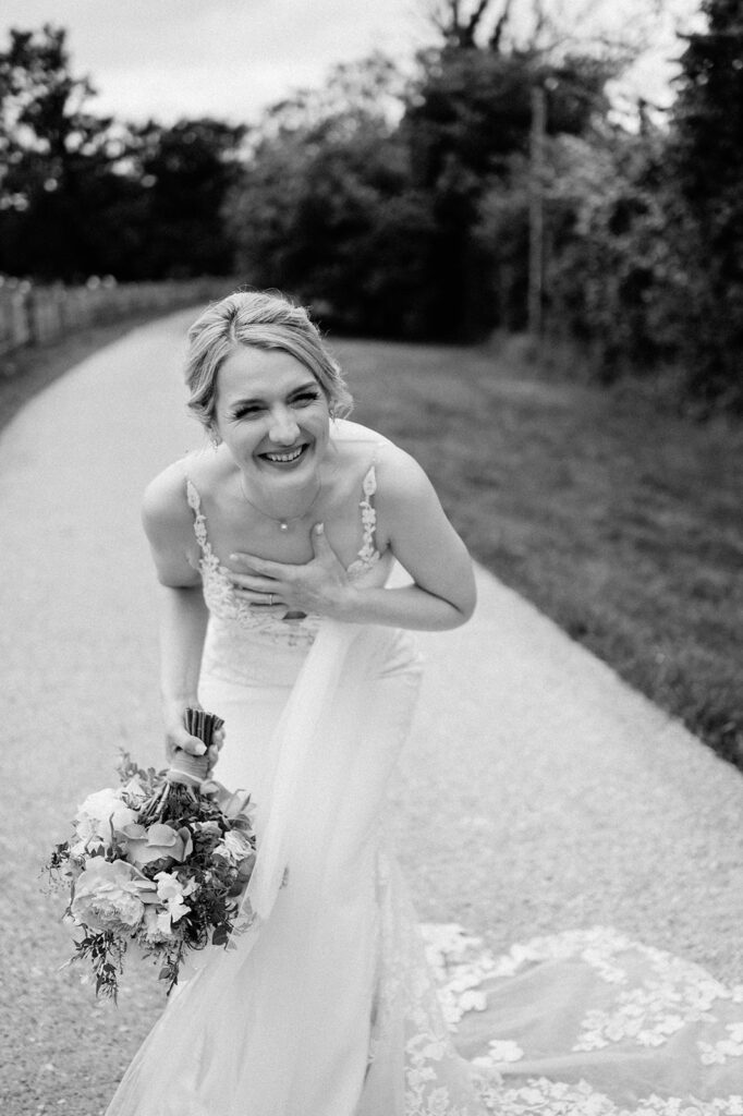 bride wearing Martina liana wedding dress at retreat east holding pink peony wedding bouquet