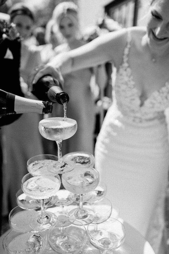 bride and groom pouring champagne into champagne tower at retreat east