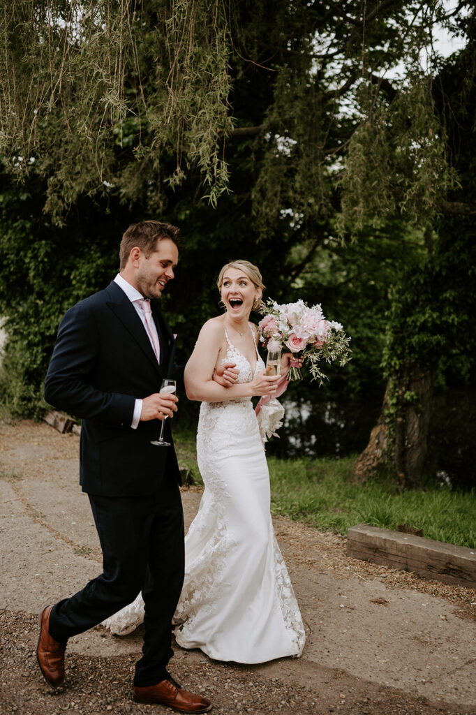 couple walking away arm in arm with champagne in hand