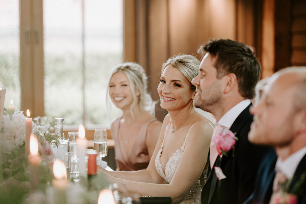 bride smiling at speeches at retreat east